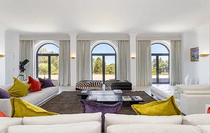 Villa lounge with tall arched windows onto the garden